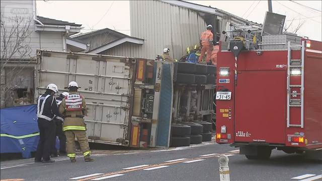 大型トレーラーが横倒しに 道路わきの住宅に突っ込み運転手けが　住人は無事