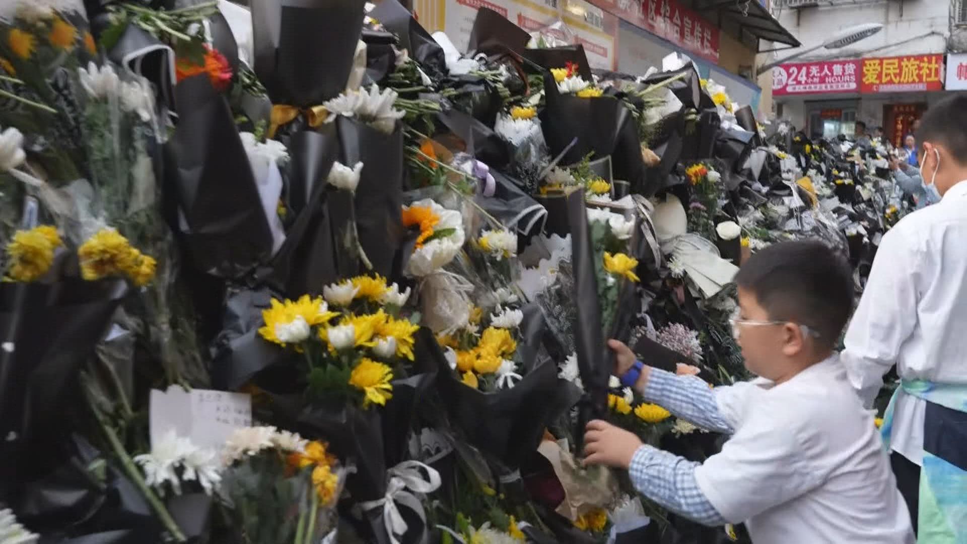 安徽省で花束を手向ける人々
