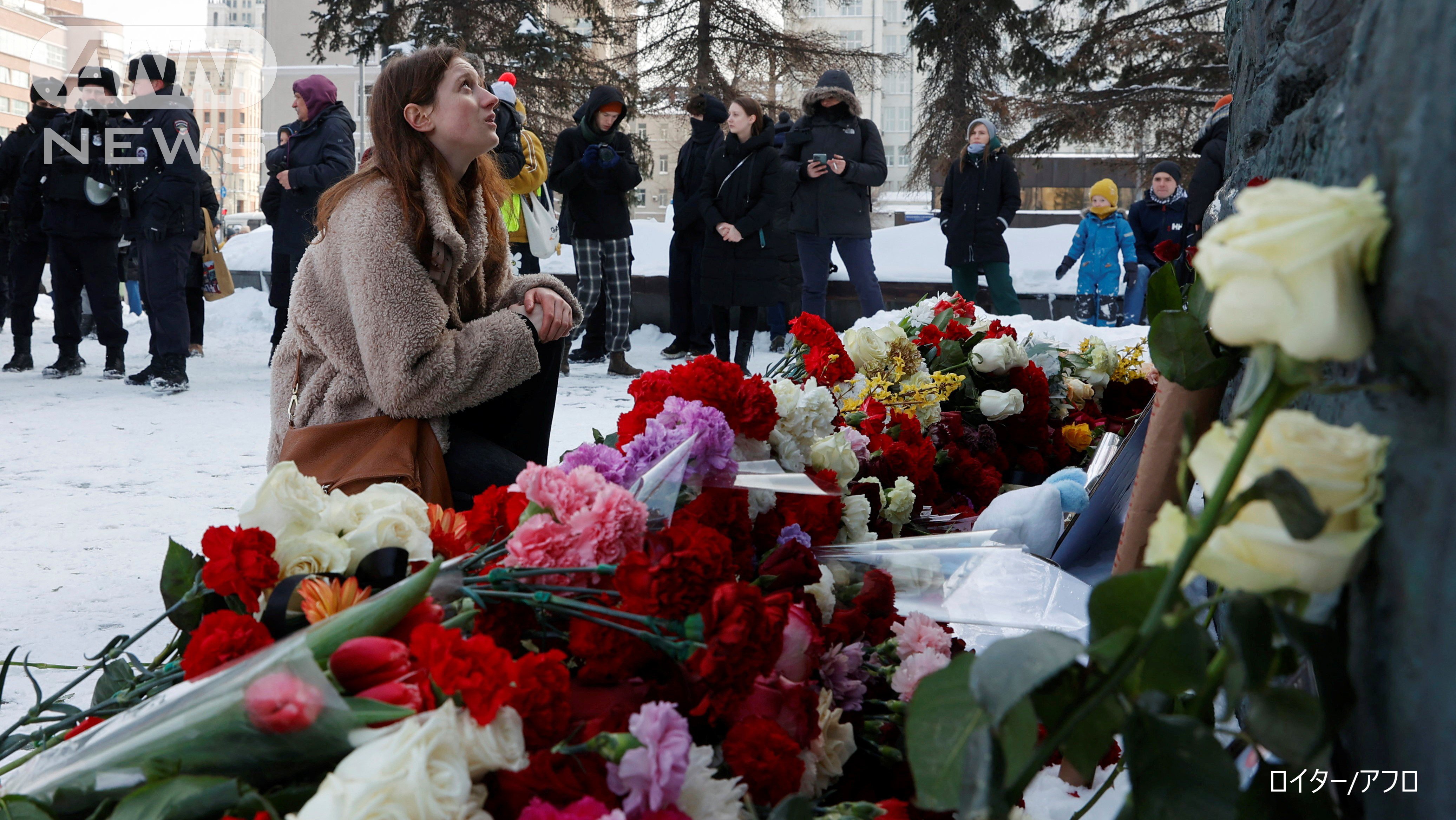 政治弾圧の犠牲者を悼む「悲しみの壁」で献花する市民と監視する治安要員　　モスクワ市　2024年2月17日　ロイター／アフロ　