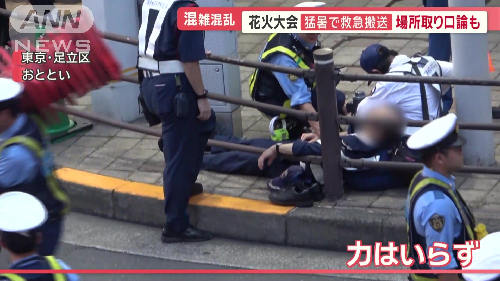 歩道の端で倒れる警備員