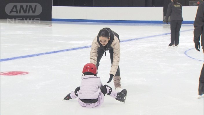 スケートに挑戦する子どもたちを優しく抱き上げる浅田さん