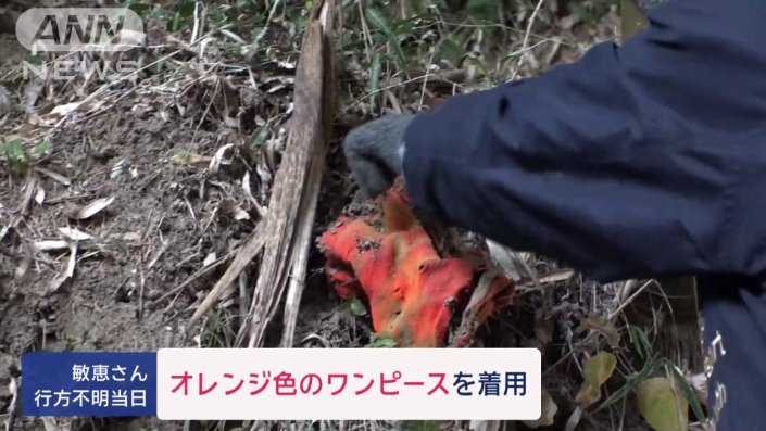 土に埋もれたオレンジ色の布