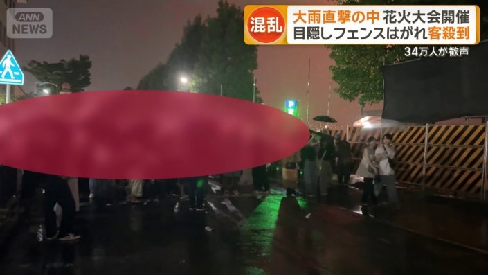 幕が垂れたフェンスの前で多くの人が滞留