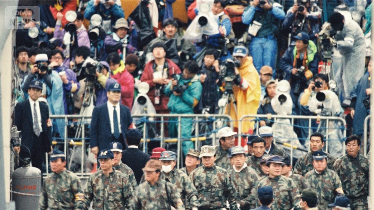 報道陣が見守るなか第6サテイアンへに向かう捜査員ら（提供　朝日新聞社）
