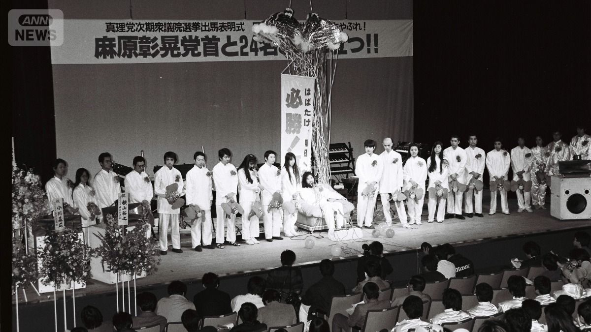 オウム真理教が結成した政党「真理党」の衆院選候補者発表で、壇上に並ぶ麻原彰晃（松本智津夫）党首と信徒たち（提供　朝日新聞社）