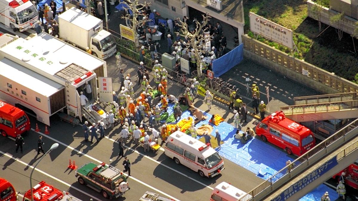 地下鉄サリン事件発生直後、営団地下鉄・築地駅から地上に運び出され、救急車などに収容される乗客ら（提供　朝日新聞社）