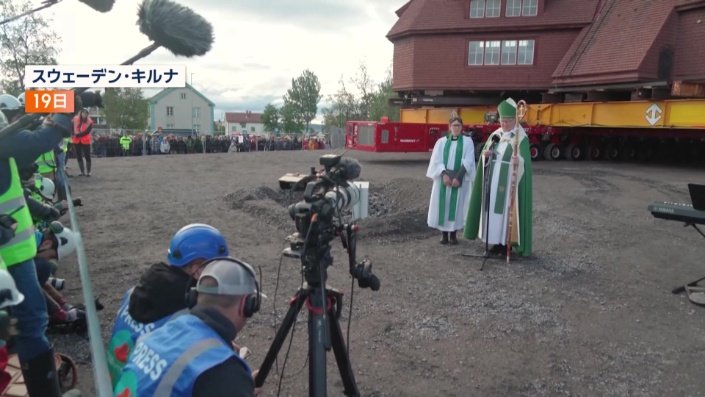 教会の司祭の後ろに…
