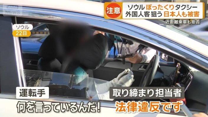 取り締まりをする職員ともめているタクシー運転手