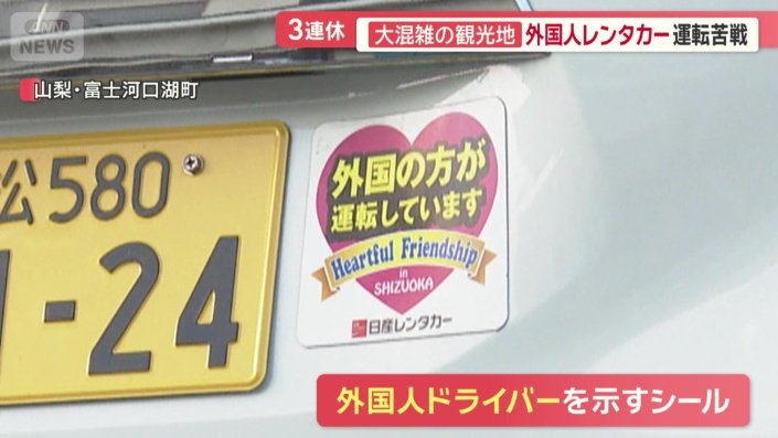 外国人が運転していることを示すシールが貼られたレンタカーも