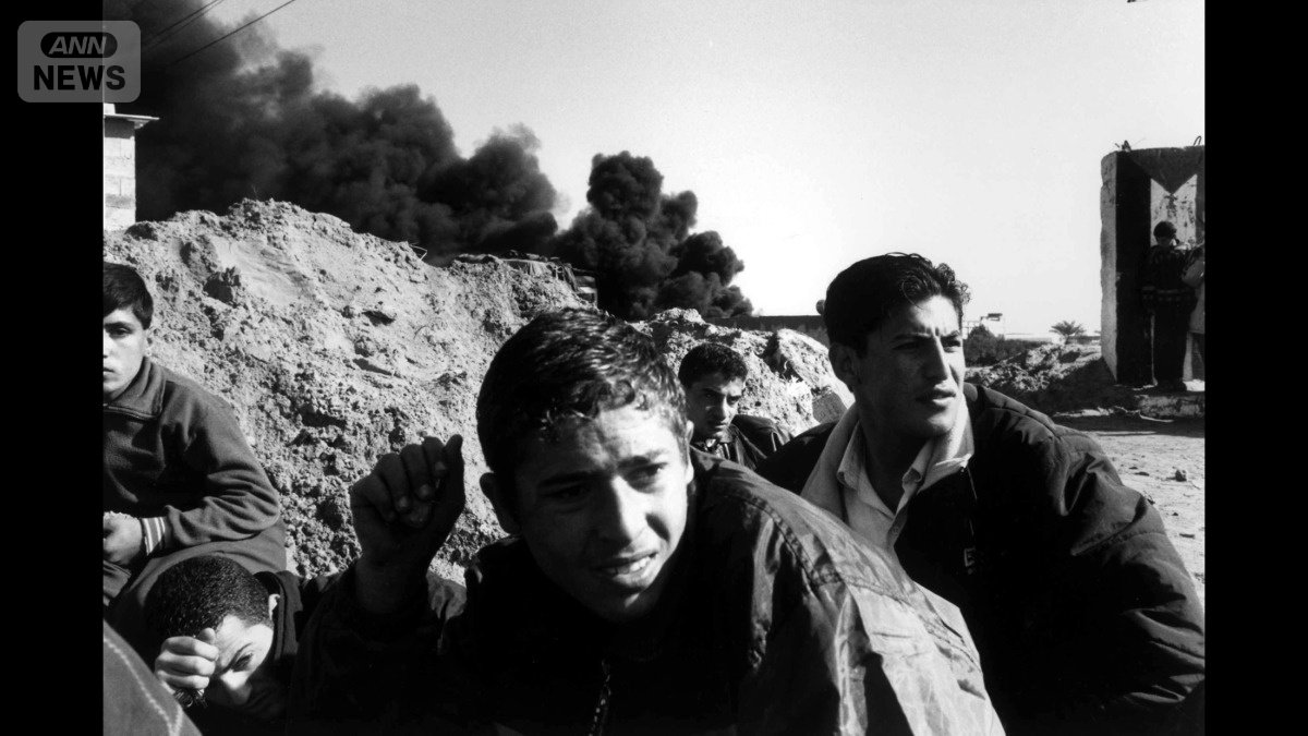 2001年、ガザ地区で石を持ち戦車から身を隠す人々