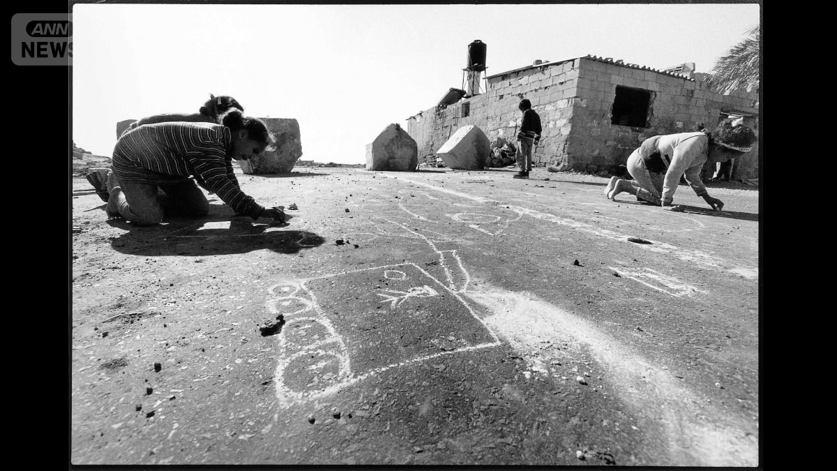 2001年、イスラエル軍に閉鎖されたガザ地区の道路で絵を描く子ども（撮影：亀山亮さん）
