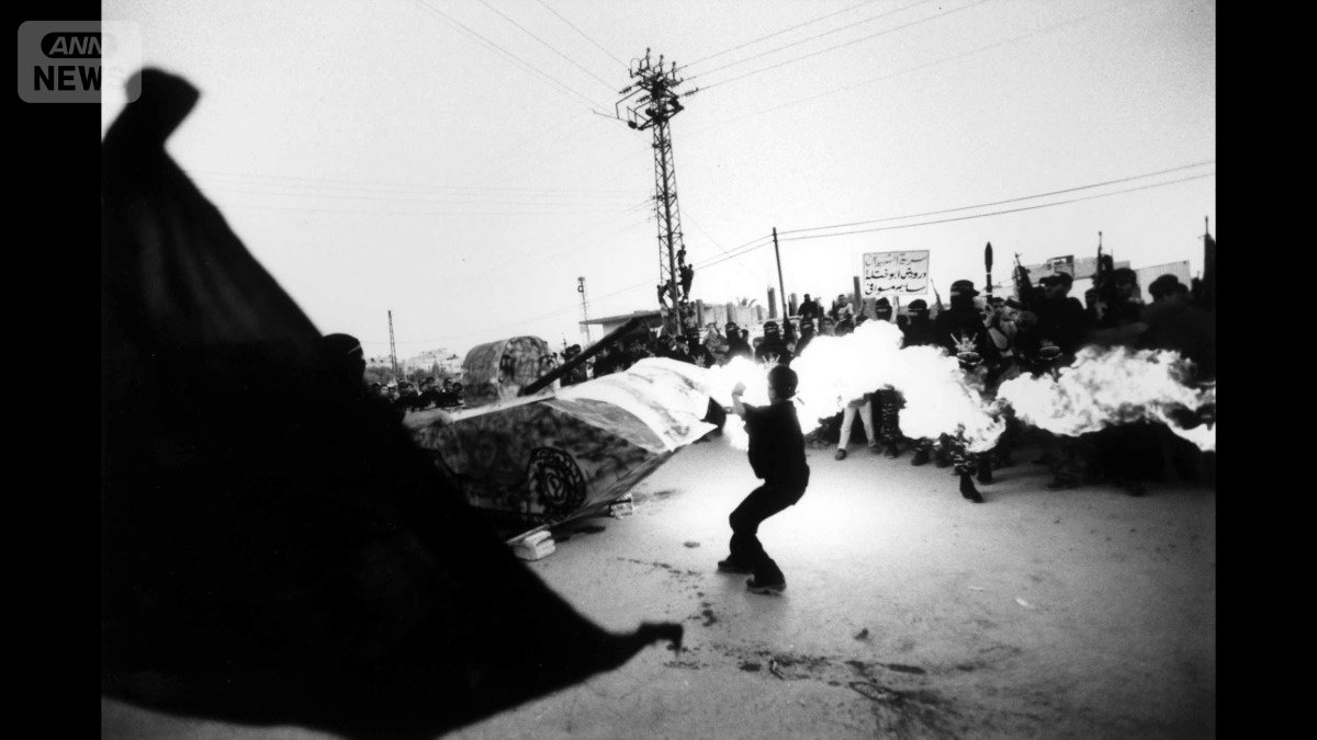 2001年、ガザ地区で開かれた武装勢力の集会で、ハリボテの戦車に火をつける少年（撮影：亀山亮さん）