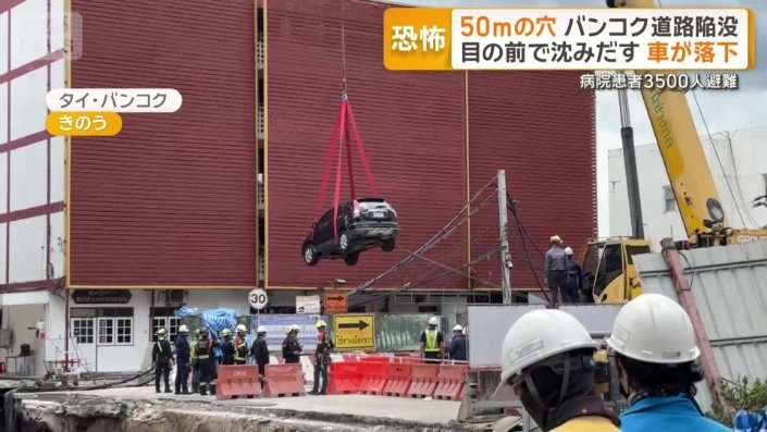 車がクレーン車に吊り上げられる