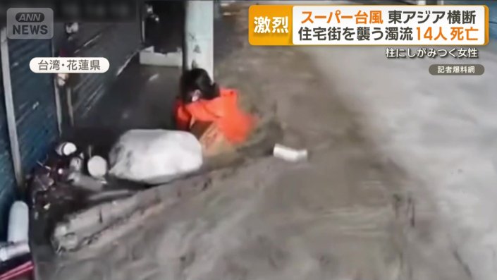 濁流の中、柱にしがみつく女性