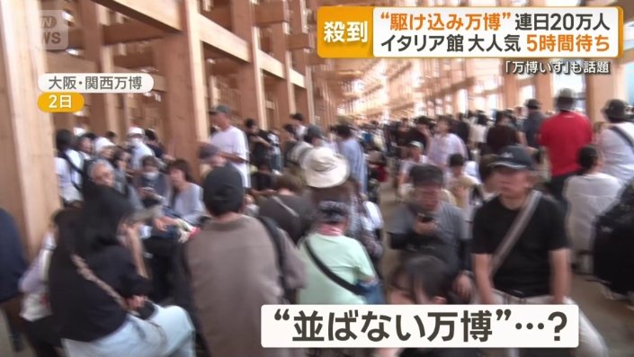 大屋根リングの端から端まで折り重なって伸びる行列