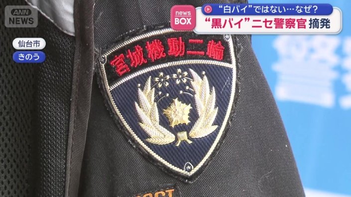 肩に警察のエンブレムのようなワッペン