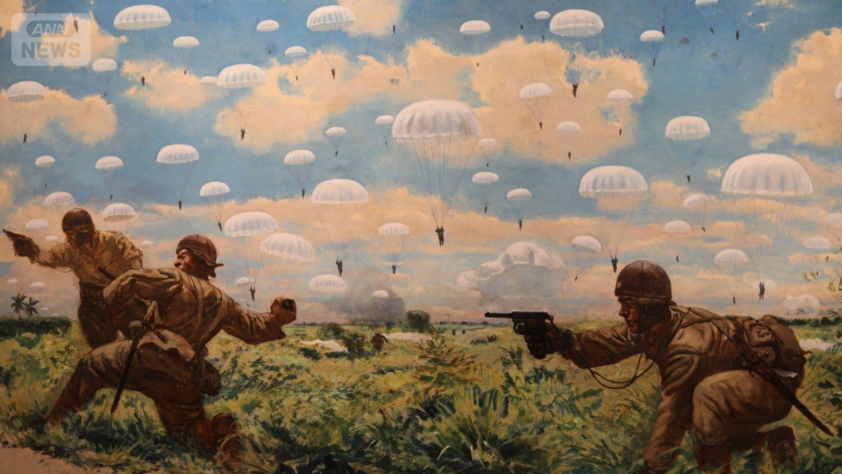 《神兵パレンバンに降下す》の一部 雲が浮かぶ青空から、白いパラシュートで兵士らが降下し、戦闘を始める