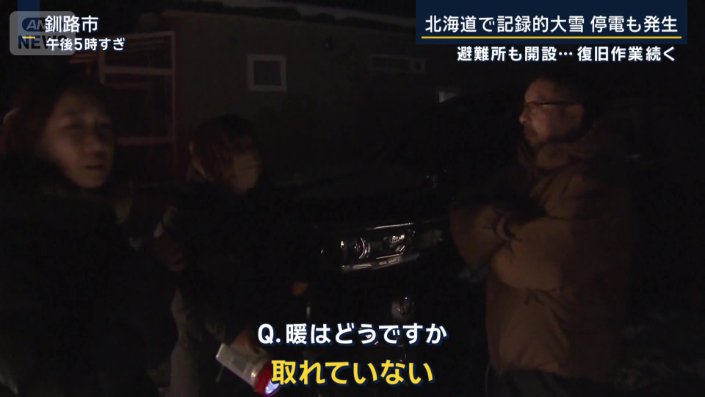 懐中電灯を手に歩く住民