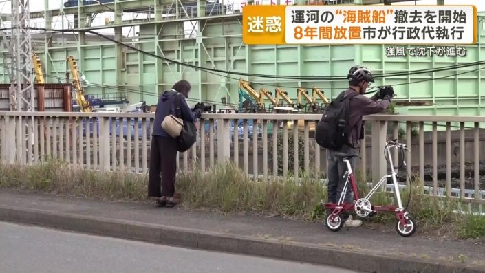 最後の姿を写真に収めようとする人