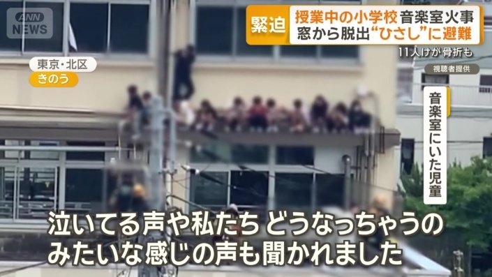 校舎の4階、ひさしの部分に児童らの姿が確認できる