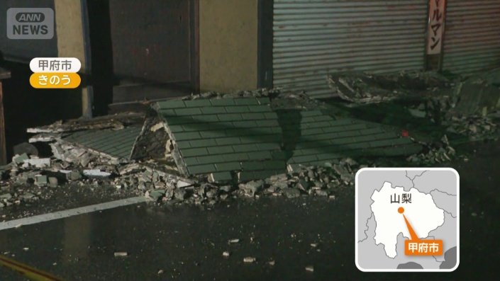 家屋の壁が崩れ道路に残骸が散らばる